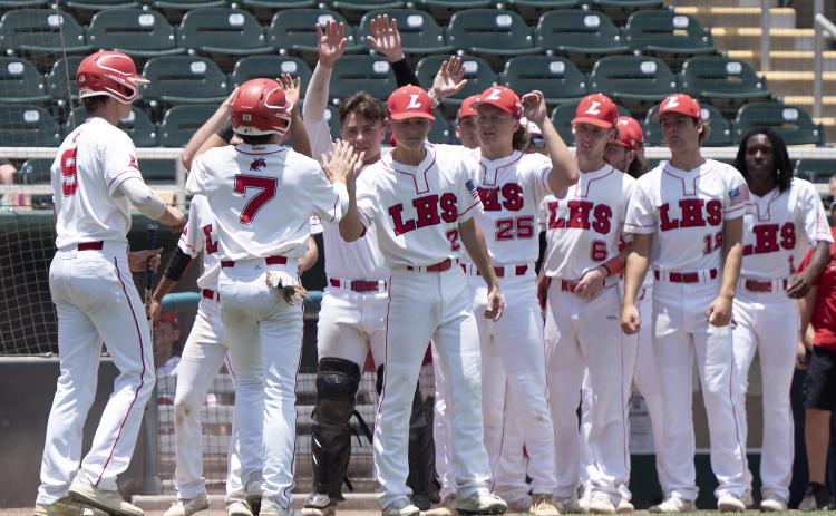 Lafayette’s Garrett Taylor (9) and Baylor Johnson (7) are greeted by teammates after scoring against Holmes County during the Class 1A state semifinals on Wednesday at Hammond Stadium in Fort Myers. (CHRIS TILLEY/Special to the Reporter)