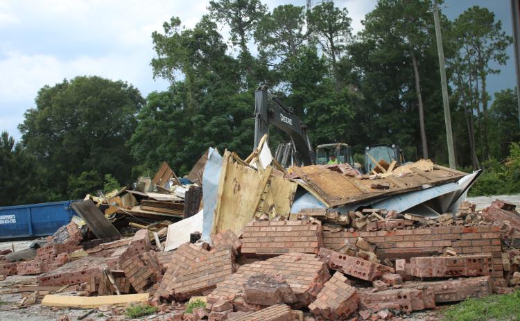 A construction crew takes down the last of the Ken’s Bar-B-Que and Steaks building on U.S. Highway 90 Wednesday afternoon to make way for a new Radiant Credit Union building. (TONY BRITT/Lake City Reporter)
