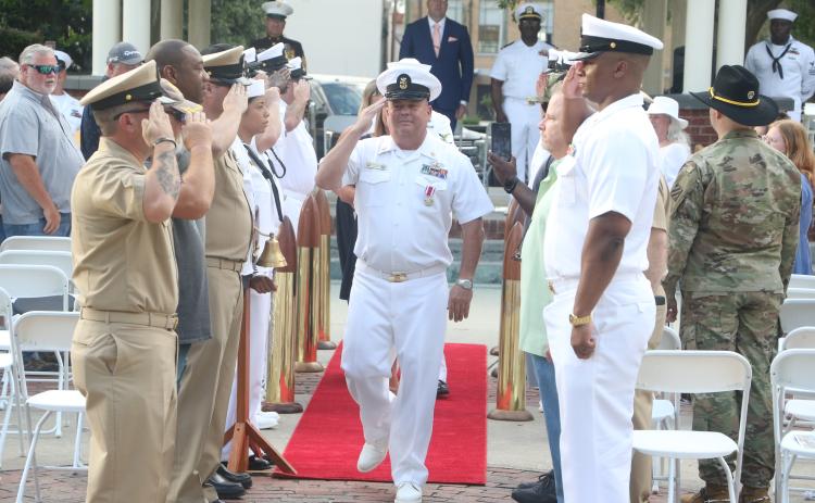 U.S. Navy Master Chief Damage Controlman Robert Ratliff salutes fellow service members as he “comes ashore” during his retirement ceremony Friday. (MORGAN MCMULLEN/Lake City Reporter)