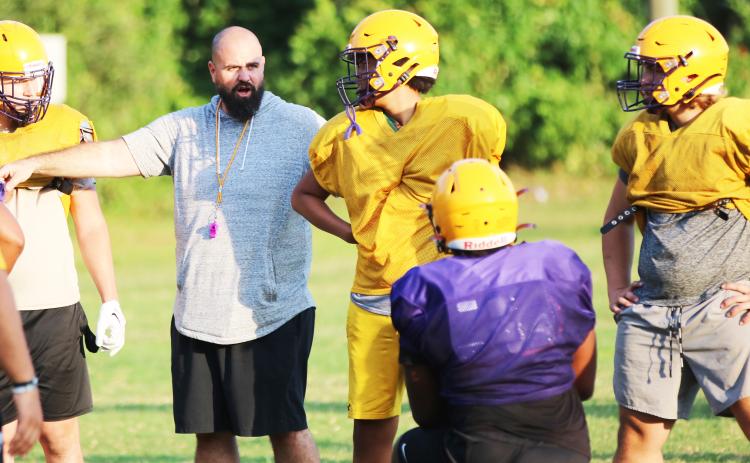 Columbia offensive line coach John Woodley works with the offensive line during Monday’s practice. (JORDAN KROEGER/Lake City Reporter)
