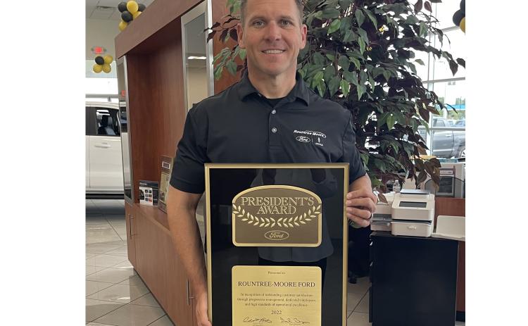 Rountree Moore Ford General Manager Stephen Jones holds up the Ford Motor Company’s President’s Award, which the company earned for outstanding customer satisfaction. (COURTESY)
