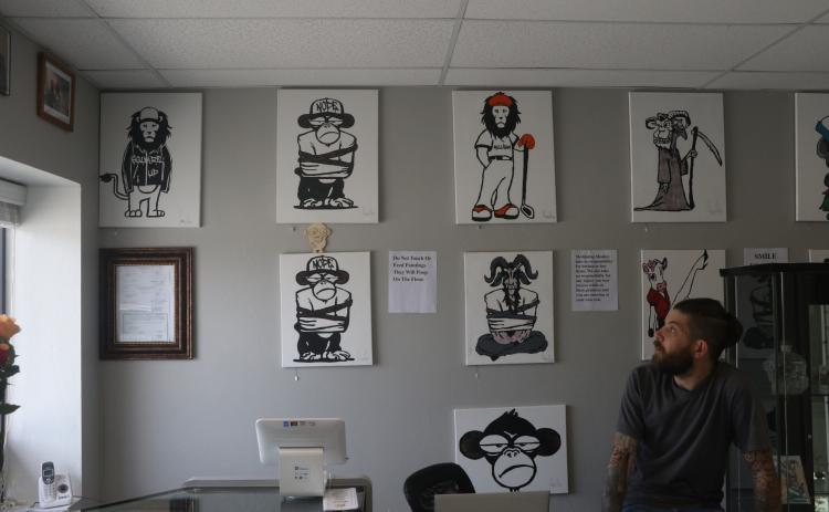 Meditating Monkey Art Emporium owner Gary Rife explains the concept behind the animal artwork Friday. (MORGAN MCMULLEN/Lake City Reporter)