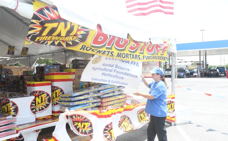 JD Morris, the Columbia High FFA alumni treasurer, adjusts a sign on the outside of the group’s fireworks tent at the Lake City Walmart on Tuesday. The fireworks tent is the FFA’s largest fundraiser. (MORGAN MCMULLEN/Lake City Reporter)