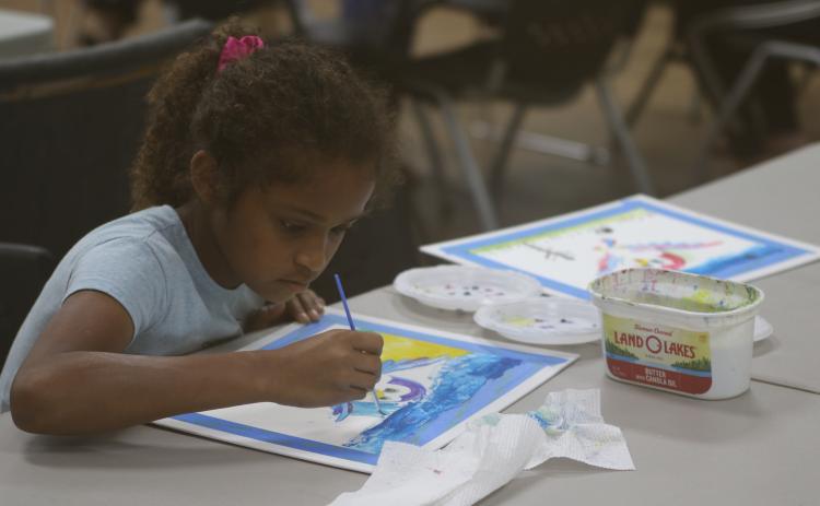Aaliyah Singh concentrates on her watercolor painting Friday during the Young Da Vinci Art Camp at the Gateway Art Gallery. (JAMIE WACHTER/Lake City Reporter)