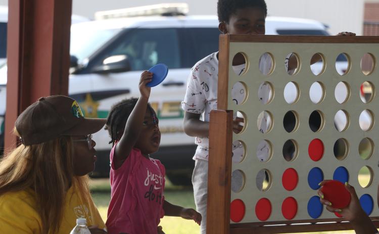Tylie Davis looks to make a play during a ‘Connect 4’ game with Tyrice Baynard as Katie McGowan looks on Friday during the Summer Nights program at Melrose Park Elementary School. (MORGAN MCMULLEN/Lake City Reporter)
