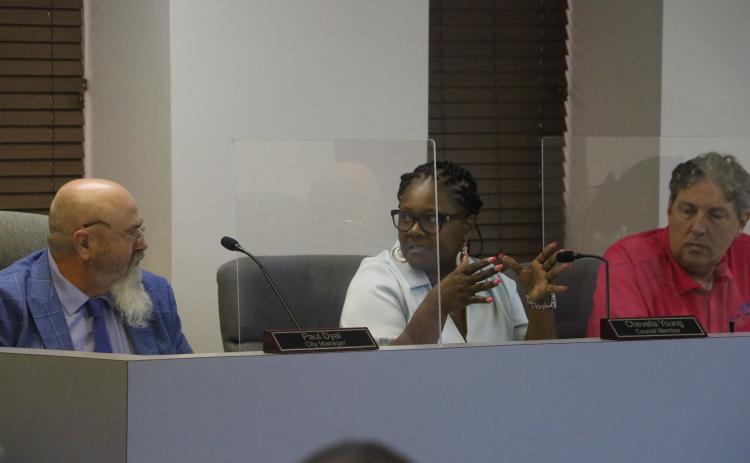 Councilwoman Chevella Young (middle) speaks to City Manager Paul Dyal as Councilman Todd Sampson listens during Monday’s Lake City Council meeting. (MORGAN MCMULLEN/Lake City Reporter)