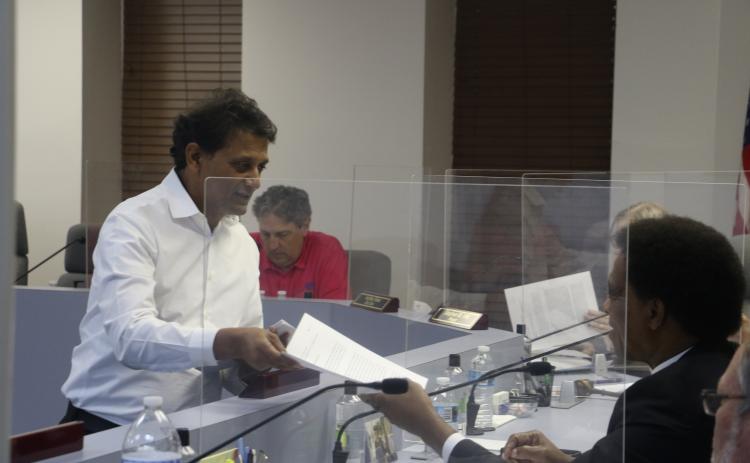 Nick Patel hands out information to the Lake City Council at Monday’s meeting about the proposed Circle K expansion. (MORGAN MCMULLEN/Lake City Reporter)
