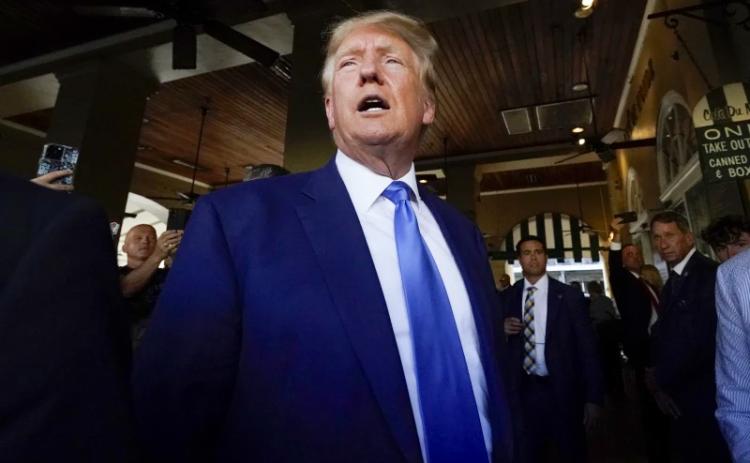 Former President Donald Trump visits Café du Monde in New Orleans on Tuesday. Trump received a new charge Thursday in the Mar-a-Lago investigation. (GERALD HERBERT/Associated Press)
