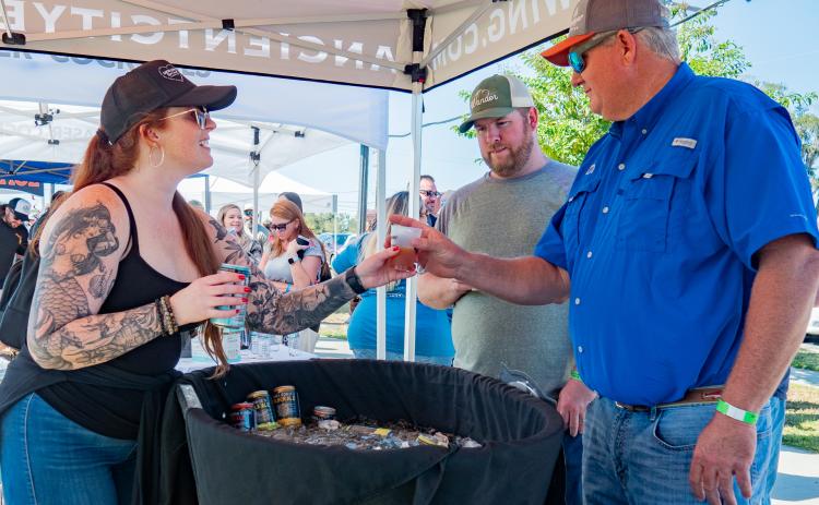 An Ancient City Brewing employee serves up a drink to a festivalgoer at last year’s Gateway City Craft Beer & Wine Festival in downtown Wilson Park. (COURTESY)