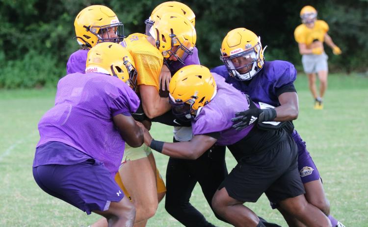 Columbia’s defense swarms to tackle receiver Camdon Frier during Friday’s practice. (JORDAN KROEGER/Lake City Reporter)