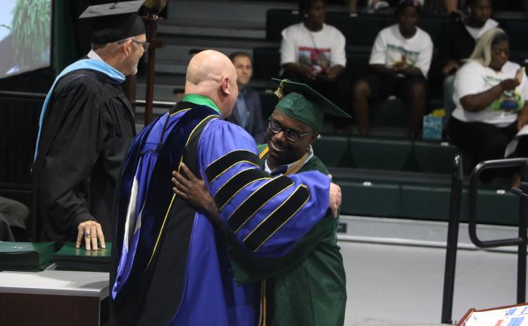 FGC student speaker Tavion Taylor (right) hugs FGC President Larry Barrett after receiving his Associate in Arts degree during Thursday’s graduation ceremony. (MORGAN MCMULLEN/Lake City Reporter)