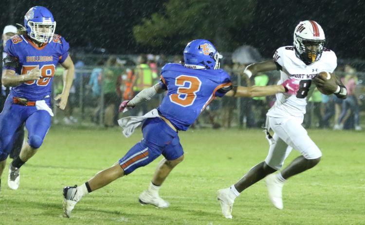 Fort White quarterback Jayden Jackson scrambles to evade a tackle by Taylor County defensive back Baylor Johnson on Friday night. (MORGAN MCMULLEN/Lake City Reporter)