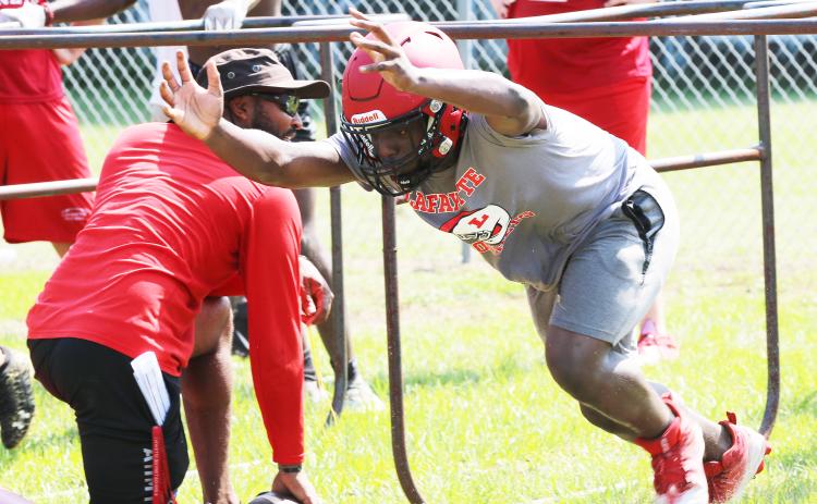 Lafayette defensive end Amarie Fleming performs a drill with head coach Marcus Edwards during Tuesday’s practice. (JAMIE WACHTER/Lake City Reporter)
