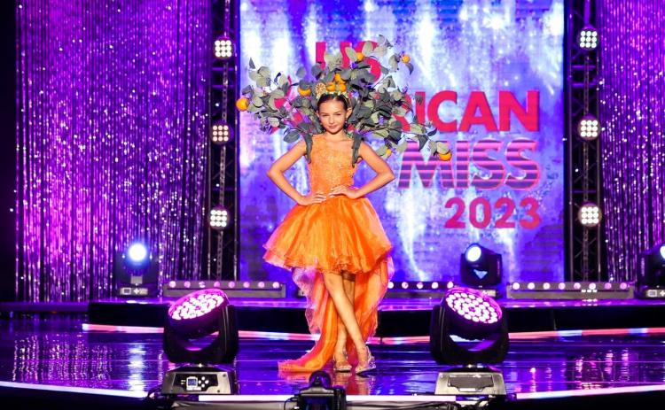 Lake City’s Molly Sue Wells poses on stage at the U.S. American Miss National Princess Pageant in Ponte Vedra Beach in her state wear costume. Wells eventually won the pageant, earning her the title of U.S. American Miss National Princess. (COURTESY)
