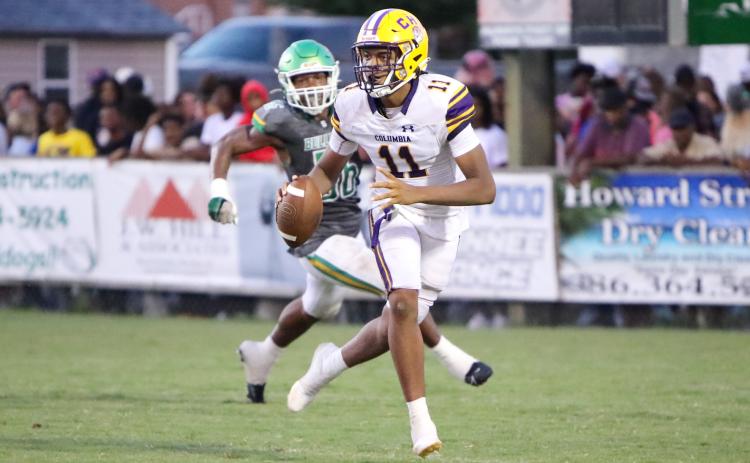 Columbia quarterback Zack Paulk scrambles away from Suwannee defensive end Ja’Darius Cherry during Friday’s Preseason Classic. (BRENT KUYKENDALL/Lake City Reporter)