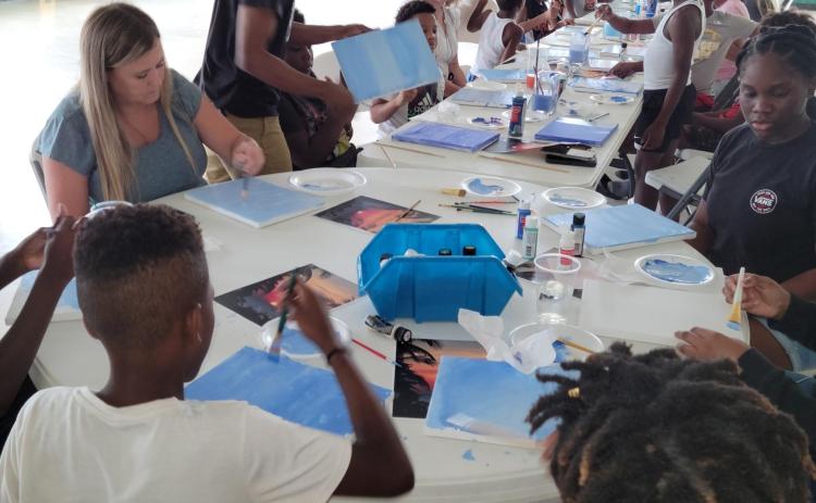 Children receive a painting lesson from Pedro Jermaine, a professional artist from Live Oak, during a Hands of Change event at Richardson Community Center. (COURTESY)