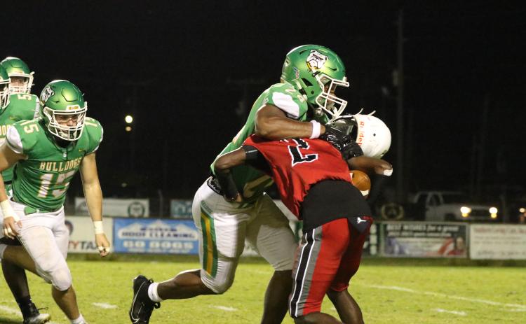 Suwannee defensive lineman JaDarius Cherry sacks Munroe quarterback Demaris Bunion on Friday night as Bunion’s helmet comes off. (JAMIE WACHTER/Lake City Reporter)