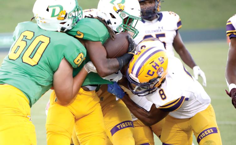 DeLand running back Ladamion Bletcher tries to power through Columbia defenders, including Markeyon Moore (8) on Friday night at Spec Martin Memorial Stadium. (BRENT KUYKENDALL/Lake City Reporter)