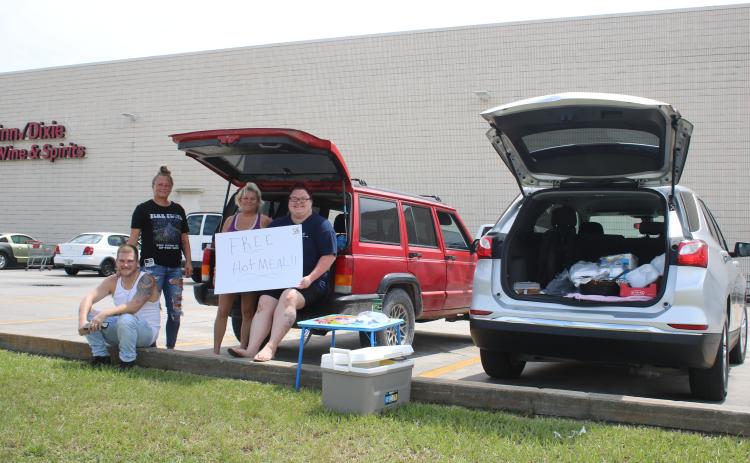 Curtis Handy, Jordana Smith, Daniels Cornuet and Haley Piercey gather outside Winn-Dixie on Friday where they were offering free hot meals to area residents following Hurricane Idalia. (TONY BRITT/Lake City Reporter)