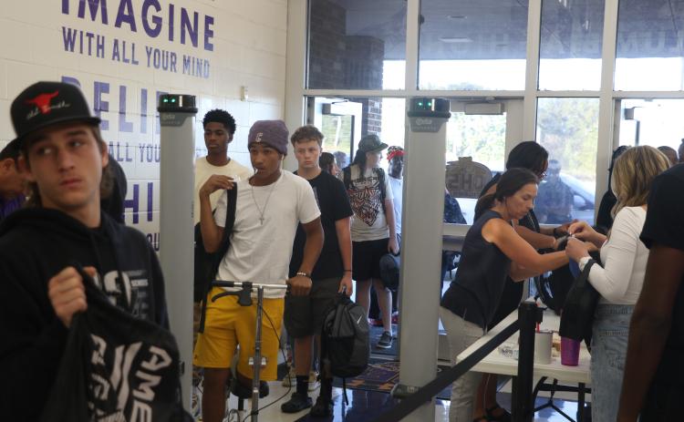 Columbia High School students pass through a metal detector at the front entrance Wednesday morning. (MORGAN MCMULLEN/Lake City Reporter)