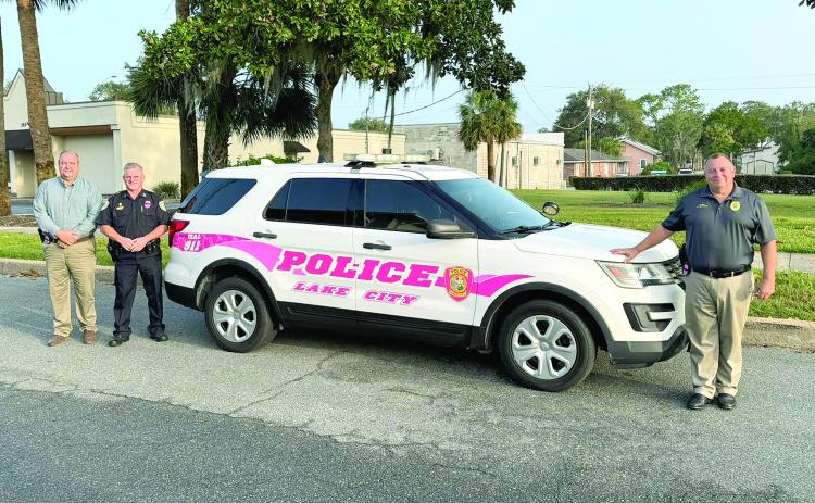 Lake City Police Department Lt. Robert Milligan (from left), Assistant Chief of Police Andy Miles and Chief Gerald Butler pose next to the department’s vehicle that has pink striping. LCPD officers are wearing pink badges this month and utilizing the vehicle to increase local breast cancer awareness. (COURTESY)