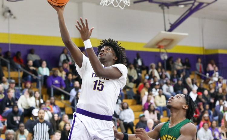 Columbia forward Zavian Douglas makes a layup ahead of Suwannee’s Ja’Darius Cherry on Tuesday. (BRENT KUYKENDALL/Lake City Reporter)