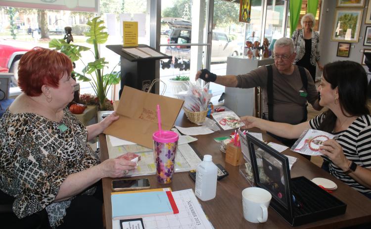 Brenda Kennedy (clockwise, from left), Art League of North Florida board secretary, John Larner and Sheila Carr, Gateway Art Gallery Curator, organize entries that have been submitted for the Gateway Art Gallery’s Christmas ornament decoration contest. (TONY BRITT/Lake City Reporter)