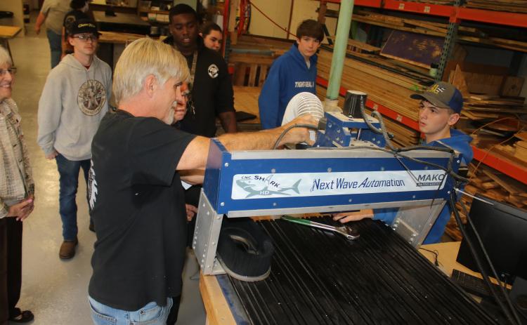 Columbia High Building, Trades and Construction Designs Technology Career Technical Education instructor Scott Dockery shows Carl Pavey one of the computer-navigated woodworking machines in the CHS woodshop Tuesday. (TONY BRITT/Lake City Reporter)