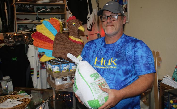 John ‘Lit’ Cole, the president of Kids Feeding Kids, holds one of the turkeys that the organization plans to give to families in need today. (TONY BRITT/Lake City Reporter)