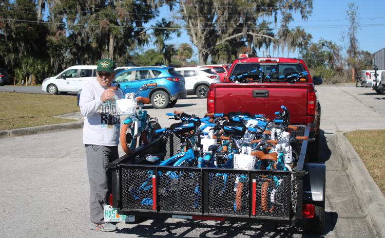 Mike Kelley, Suwannee Bicycle Association vice president, unloads a child’s bike from a trailer on Wednesday afternoon. (TONY BRITT/Lake City Reporter)