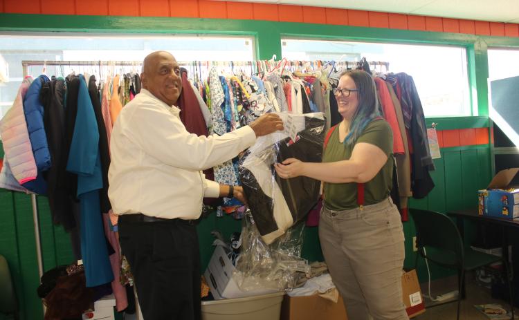 Philip Mobley (left), NorthStar Family Resource Center executive director, hangs clothing at the facility in January with help from Christen Lancaster, NorthStar Community Center Community Research Coordinator. (FILE)