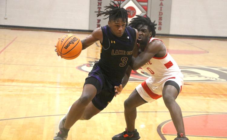 Columbia guard Zamarion Jones drives past Santa Fe’s NyShaun Jenkins on Friday night. (MORGAN MCMULLEN/Lake City Reporter)