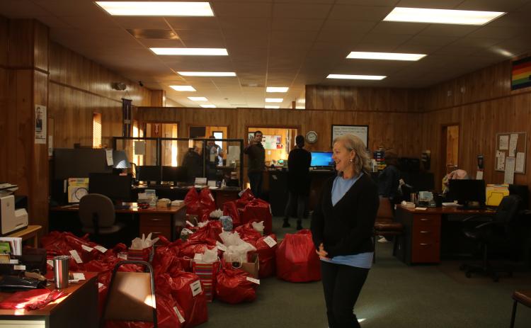 Joanie LeRoy, a Christian Service Center volunteer, looks over bags of toys and other gifts that were prepared for distribution to local families on Monday. (TONY BRITT/Lake City Reporter)