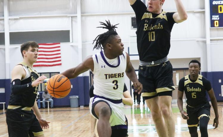 Columbia guard Zamarion Jones passes around Buchholz forward Gabe Thompson during the Hitchcock’s Challenge on Friday. (JORDAN KROEGER/Lake City Reporter)