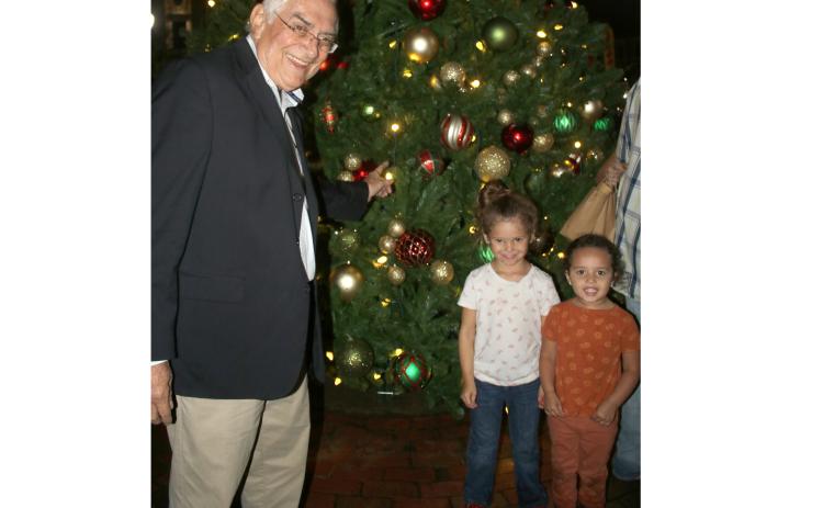 Lake City Mayor Stephen Witt (from left) stands with Aleah Hillhouse, 5, and Autumn Hillhouse while showing the youngsters ornaments on the city’s Christmas Tree during Sunday’s tree lighting ceremony. (TONY BRITT/Lake City Reporter)