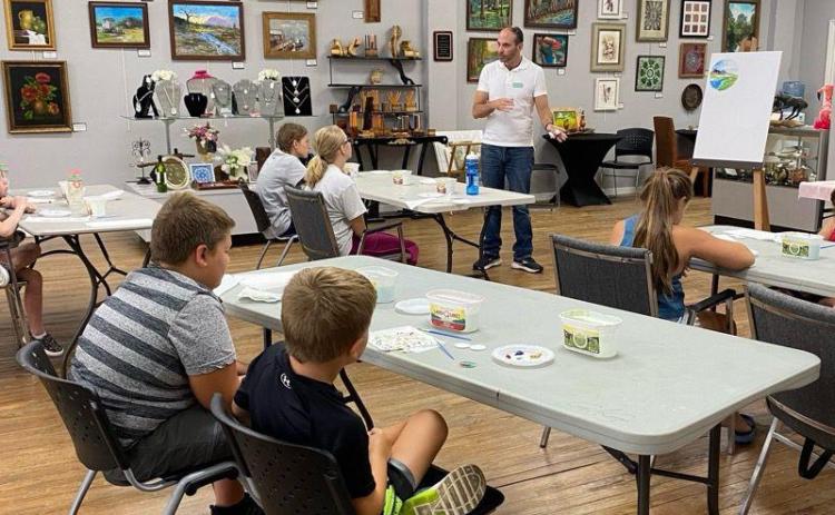 Jeffrey Moore (standing), a Gateway Art Gallery member, instructs Junior Youth Art League class  students during a recent session. (COURTESY)