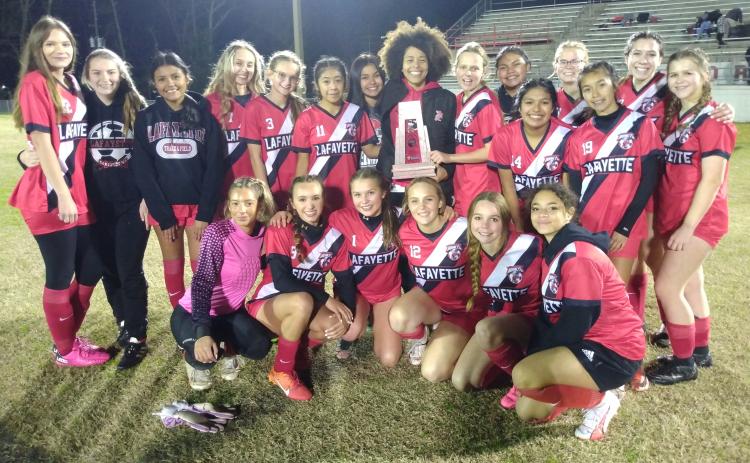 Lafayette's girls soccer team celebrates with the District 2-2A trophy after defeating Trenton on Tuesday night. (CONCEPCION LEDEZMA/Special to the Reporter)