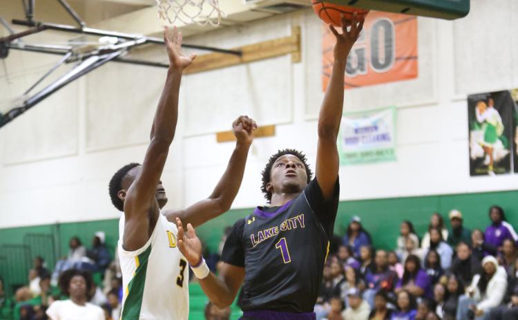 Columbia guard Marlin Haywood makes a layup while being defended by Suwannee guard MJ Rossin on Tuesday night. (PAUL BUCHANAN/Special to the Reporter)