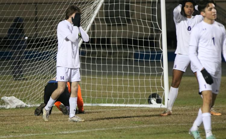 Columbia defenders Bobby Shotwell (14), Eduardo Morales (6) and Jonathan Pineda (1) react to a Clay goal as goalkeeper Augustus Mock sits on his knees in the goal during Monday's District 2-5A semifinal. (JORDAN KROEGER/Lake City Reporter)