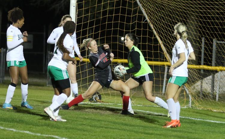 Suwannee goalie Layla Merola stops a shot just as Santa Fe’s Amelia Whitehurst crashes into the box in the second half of Wednesday’s District 2-4A championship. (MORGAN MCMULLEN/Lake City Reporter)