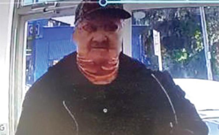 A still image from a North Florida Pharmacy surveillance camera in Fort White allegedly shows Jesse Moore in the act of robbing the store on Jan. 13, 2022. (COURTESY)