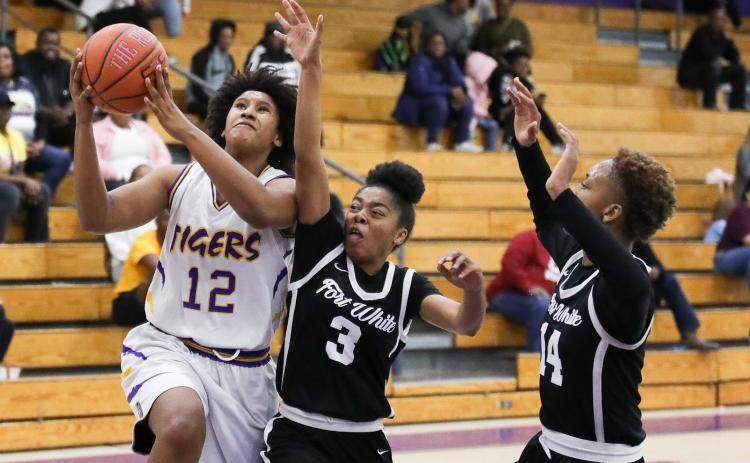 Columbia forward Jolena Gardner drives past Fort White guard Jermauni Byrd (3) and forward Isreal Hart (14) on Friday night. (BRENT KUYKENDALL/Lake City Reporter)