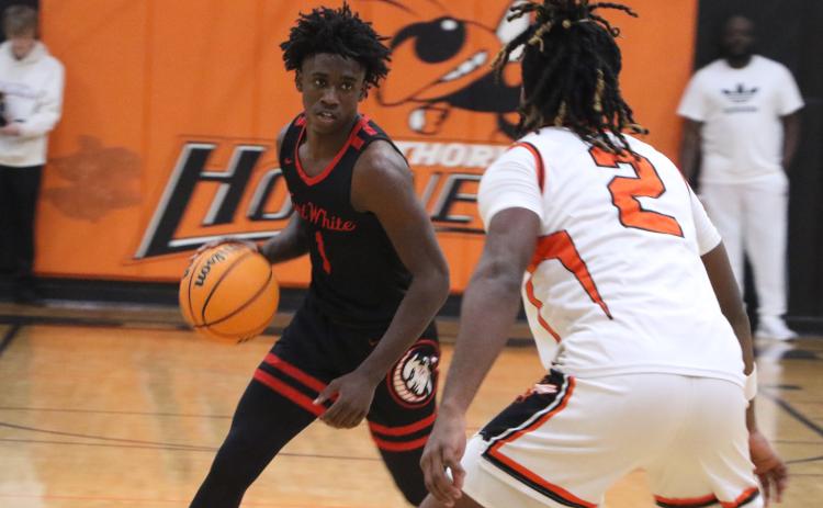 Fort White guard Jayden Jackson sizes up Hawthorne's Caleb Rollerson in the first half of Thursday's Region 3-1A semifinal. (MORGAN MCMULLEN/Lake City Reporter)