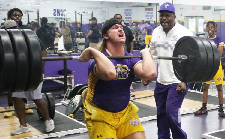 Columbia lifter Caden Bolstein raises the bar up for the clean and jerk while head coach Brian Allen yells encouragement during Wednesday’s tri-meet against Buchholz and Hamilton County. (JORDAN KROEGER/Lake City Reporter)
