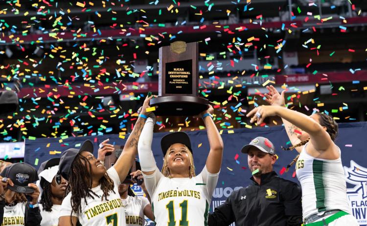 FGC’s Makenzie Phillian lifts the NJCAA championship trophy alongside Klaudia Taylor (7) and head coach Ricky Hufty after the Timberwolves won the inaugural NJCAA title on Saturday at Mercedes-Benz Stadium in Atlanta. (COURTESY OF NFL FLAG)