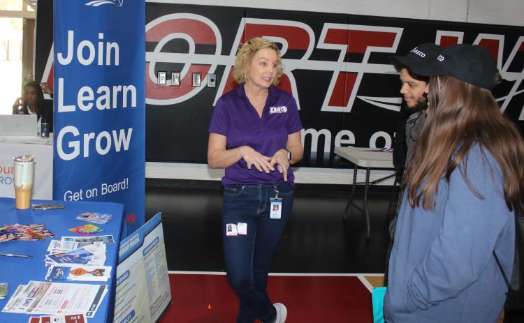 Rose Jones (from left), a Florida Department of Transportation employee, talks to Jaden Klys and Angelis Owens during the Fort White High School Career Fair on Thursday at the school gymnasium. More than 40 vendors attended the session telling students about post high school education and career opportunities. (TONY BRITT/Lake City Reporter)