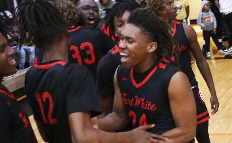 Fort White guard Darion Brinson celebrates with teammates after Fort White knocked off top-seeded Hawthorne 56-51 in the Region 3-1A semifinals on Thursday. (MORGAN MCMULLEN/Lake City Reporter)