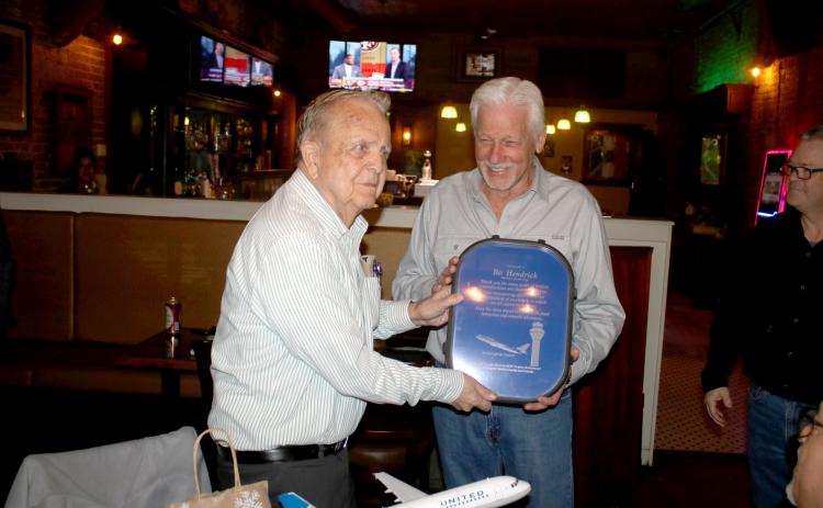 Bo Hendrick (left), who has worked at the Lake City Gateway Airport for more than 59 years, receives a gift Tuesday from Loren Triefenback from United Airlines. (TONY BRITT/Lake City Reporter)