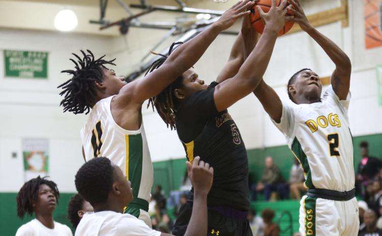 Columbia forward Jalen Gaskins (middle) fights for a rebound with Suwannee guards Jamarcus Cherry (11) and Jhy Smith (2) during Tuesday’s game. (PAUL BUCHANAN/Special to the Reporter)