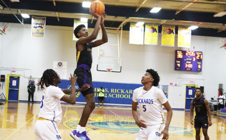 Columbia guard Noah Wilson shoots while defended by Rickards guard Chadwick Ellenwood (left) and forward Benjamin Plummer (5) during the District 2-5A championship on Saturday. (MORGAN MCMULLEN/Lake City Reporter)